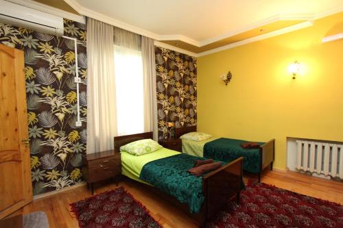 a hotel room with two beds and a window at Guesthouse Goliati in Kutaisi