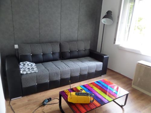 a black couch in a living room with a table at DRS apartment, fully renovated flat in Budapest