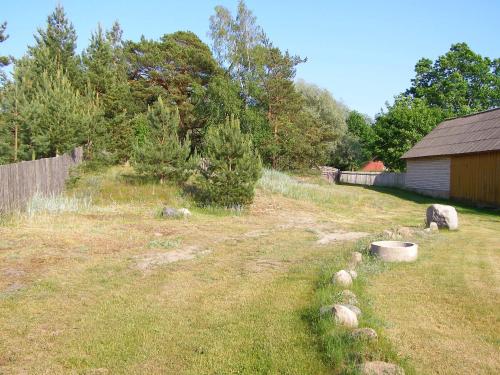 a backyard with a yard with a fence and a building at Treimani Puhkemaja in Treimani