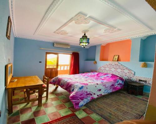 a bedroom with a bed and a table in it at La Perle Du Drâa in Zagora