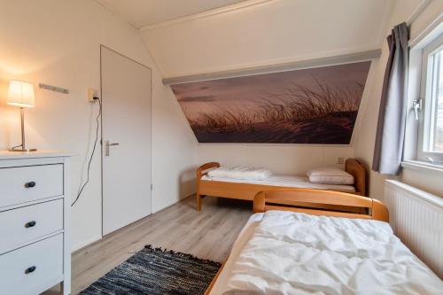 a small bedroom with a bed and a window at De Snip in Callantsoog