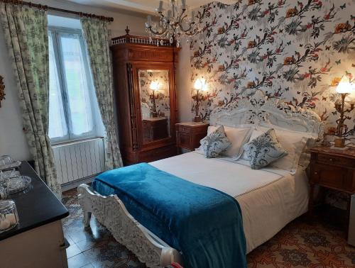 ein Schlafzimmer mit einem Bett mit einer Blumenwand in der Unterkunft Maison du Coquelicot in Tourouzelle