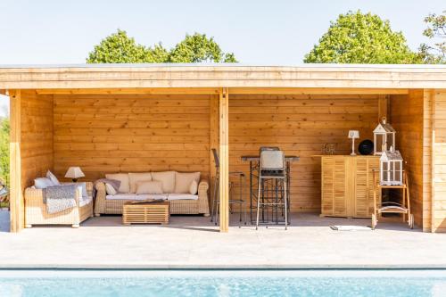 a wooden pavilion with a couch and a table at A la source de Lavis in Houyet