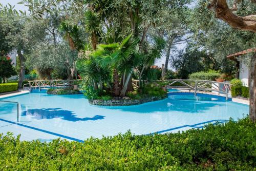 duży błękitny basen z drzewami i krzakami w obiekcie Apartment Alan w Sorrento