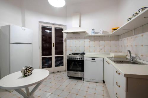 Biała kuchnia z kuchenką i zlewem w obiekcie Apartment Alan w Sorrento