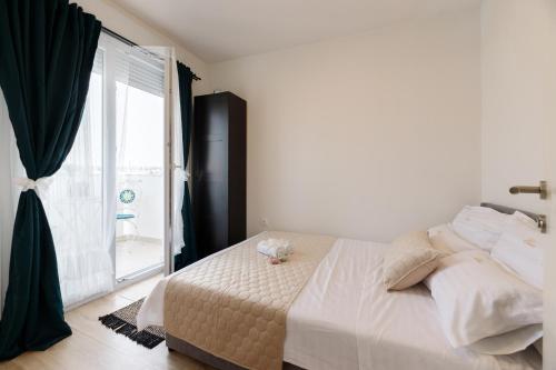 - une chambre avec un lit et une grande fenêtre dans l'établissement Apartman Elena, à Biograd na Moru