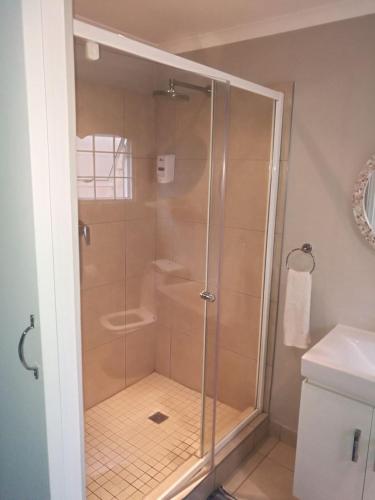 a shower with a glass door in a bathroom at 8A Oyster Crescent in Durban