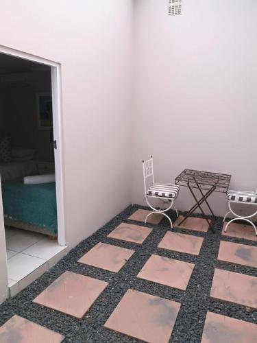 a room with two chairs and a table and a table at 8A Oyster Crescent in Durban