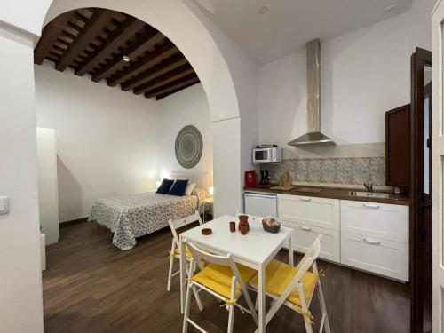 eine Küche und ein Esszimmer mit einem Tisch und Stühlen in der Unterkunft Apartamentos Turísticos Mamelón in Jerez de la Frontera