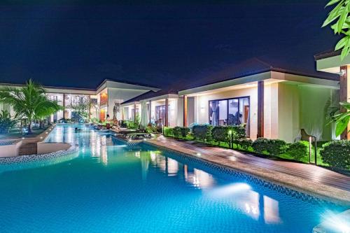 a swimming pool at a resort at night at Amphitrite Resort in Panglao