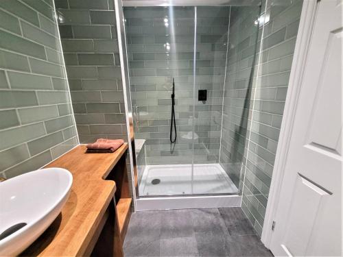 a bathroom with a shower and a sink and a tub at New County Hotel & Serviced Apartments by RoomsBooked in Gloucester
