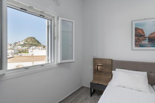a bedroom with a bed and a large window at Balliu Apartment in Triovasálos