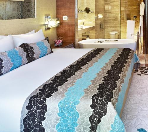 a hotel room with a bed and a bath tub at Taj City Centre Gurugram in Gurgaon