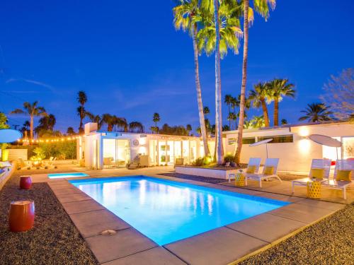 ein Pool vor einem Haus mit Palmen in der Unterkunft The Arrow in Palm Springs