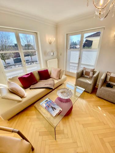 a living room with a couch and a table at Villa am Steinhuder Meer App Suite-La Fleur-mit Pantry Küche, Luftreinigungssystem, Garten, WLAN in Steinhude