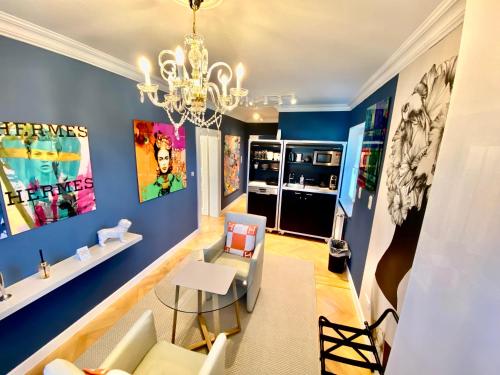 a living room with blue walls and a chandelier at Villa am Steinhuder Meer App Suite-La Fleur-mit Pantry Küche, Luftreinigungssystem, Garten, WLAN in Steinhude