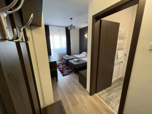 a door to a room with a bedroom and a bed at Motel Infinit in Târgu Jiu
