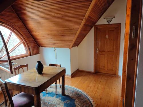 comedor con mesa y techo de madera en La Șicu, en Breaza