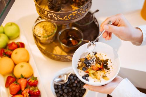 a person eating a bowl of food with a spoon at Landhotel Postwirt in Grafenau