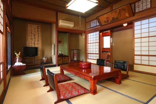 a dining room with a wooden table and chairs at Chitosekan in Nozawa Onsen