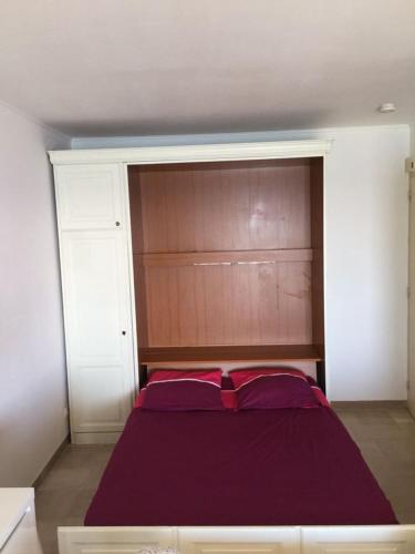 une chambre avec un grand lit avec une tête de lit en bois dans l'établissement Studio Cannes - Front de mer, à Cannes