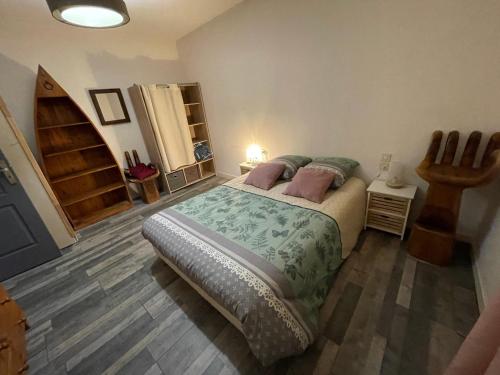 a bedroom with a bed and a wooden floor at Aurillac, appartement au centre de la ville in Aurillac