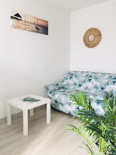 un salon avec un canapé et une table dans l'établissement studio cosy et moderne au couchant situé 150m de la plage -avec PARKING GRATUIT PRIVE - 25m2 - climatisé - balcon - wifi gratuit, à La Grande Motte