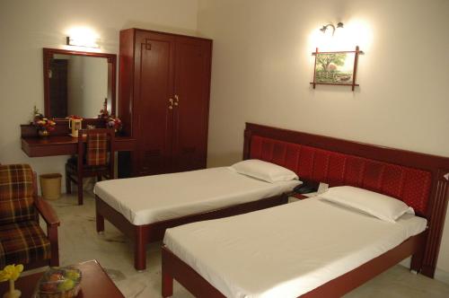 Postel nebo postele na pokoji v ubytování Hotel Gnanam