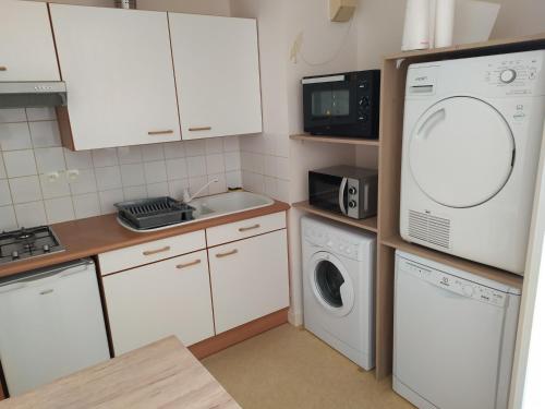 une cuisine avec un lave-linge et un micro-ondes dans l'établissement T2Bis Cosy avec 6 couchages - 100m de la mer, à La Rochelle