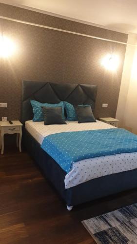 a bedroom with a bed with blue sheets and blue pillows at Laguna Apartament in Brăila