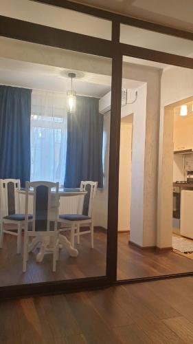 a dining room with a table and chairs and a mirror at Laguna Apartament in Brăila