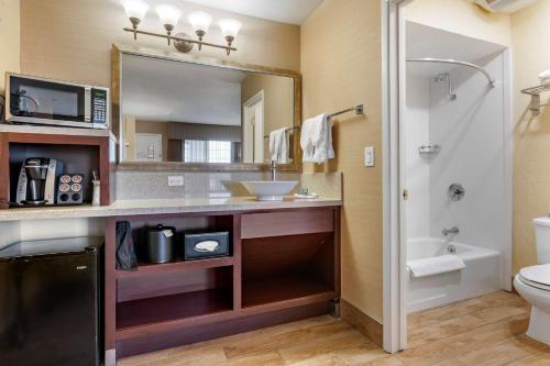 a bathroom with a sink and a mirror and a toilet at Best Western Inn Santa Clara in Santa Clara