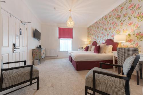 a bedroom with a bed and two chairs in a room at Florence House Boutique Hotel and Restaurant in Portsmouth