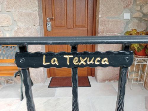 una panchina nera davanti a una porta di La Texuca a Carreña de Cabrales