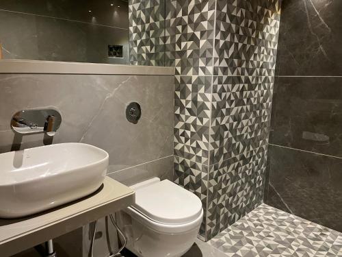 a bathroom with a sink and a toilet and a shower at Suvidha Suites in Vasai
