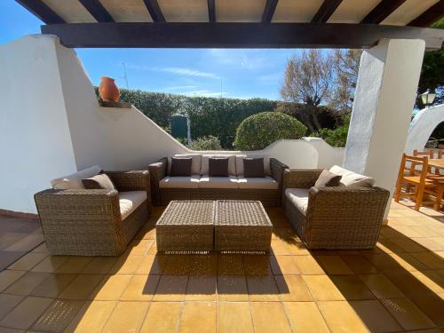 un patio con 2 sofás y una mesa de centro en Villa con piscina privada y gran jardín en Cala'n Bosch