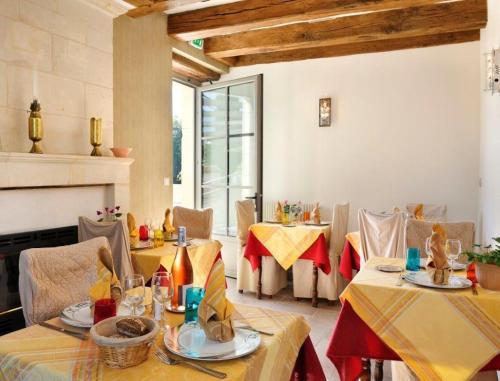 un restaurant avec des tables et des chaises et une cheminée dans l'établissement Hôtel Auberge de la Bonde logis, à Langeais