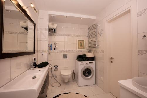 a white bathroom with a washing machine in it at Cozy Center Druskininkai in Druskininkai