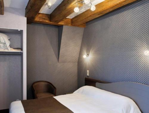 1 dormitorio con cama, mesa y techo en Logis Hôtel Auberge de la Bonde, en Langeais