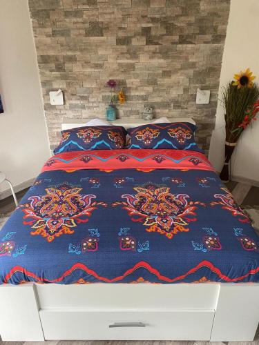 uma cama com um edredão e almofadas azuis em GÎTE PRÈS DE LA FERME em Pfastatt