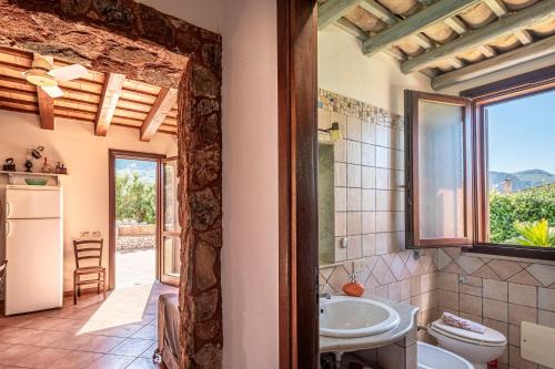 a bathroom with a sink and a toilet and a window at Villa Mafaradda a pochi passi dal Mare in Custonaci