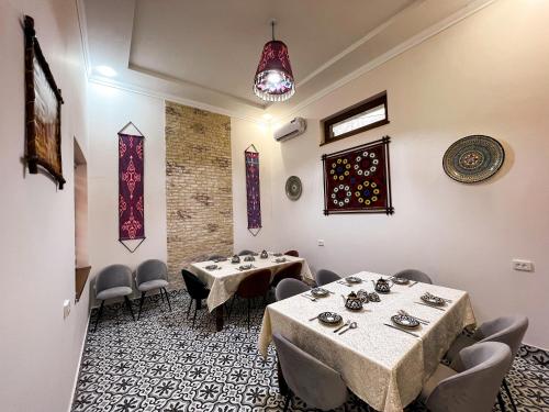 een restaurant met 2 tafels en stoelen in een kamer bij Бутик-отель CHORBOG in Samarkand