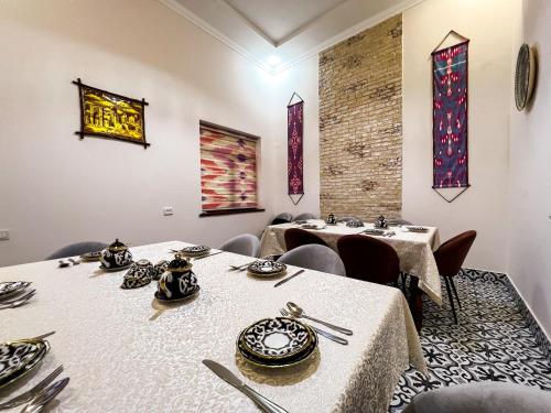 een eetkamer met twee tafels en stoelen bij Бутик-отель CHORBOG in Samarkand