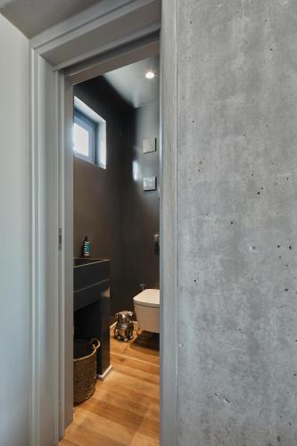 a bathroom with a concrete wall and a bath tub at My Santorini Villa, Pyrgos Luxury in Pirgos