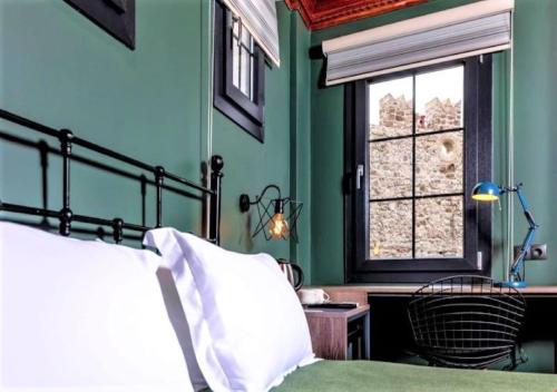 Sunset Boutique Hotel Marmaris في مرماريس: غرفة نوم بجدران خضراء وسرير ونافذة