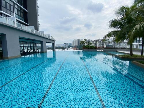 uma grande piscina azul com palmeiras e um edifício em Lily and Loft - Queensville @ Kuala Lumpur - Netflix em Kuala Lumpur
