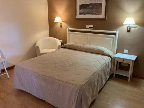 a hotel room with a bed and a chair at Hotel Rural Mariblanca in Sacedón