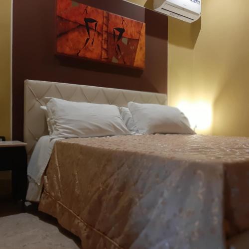a bed in a bedroom with a painting on the wall at B&B miccoli in Grottaglie