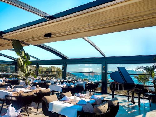 a restaurant with tables and a piano in a building at Roas Hotel in Bitez