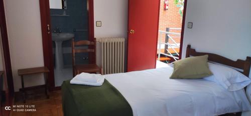 a bedroom with a bed and a bathroom with a sink at Posada Ojedo Los Ñeros in Ojedo